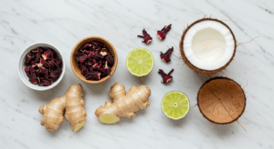 Copo com Elixir de Hibisco, Gengibre e Coco, decorado com limão e hortelã.