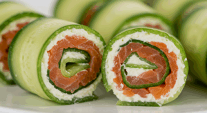 Enroladinhos de pepino com salmão defumado, prontos para servir.